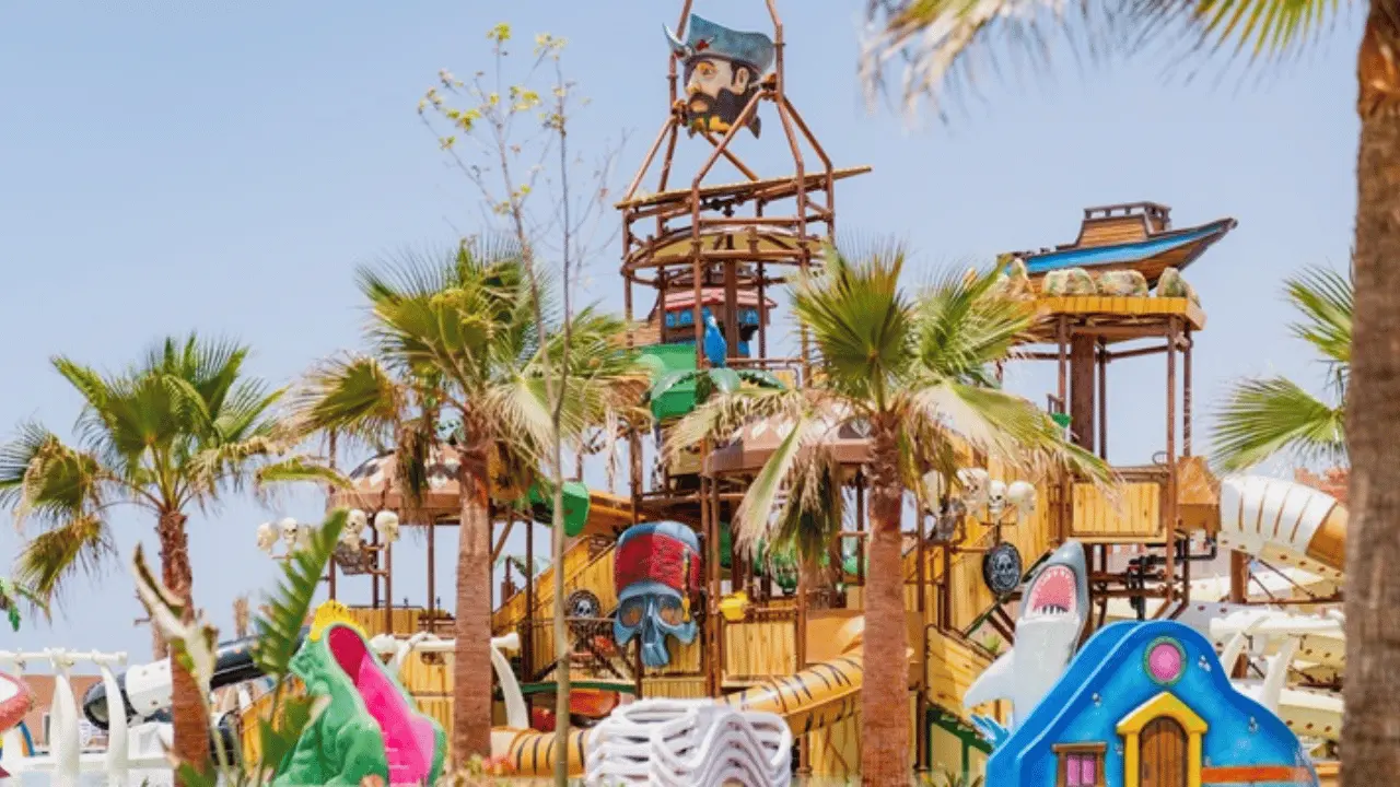Vue panoramique du parc aquatique DANIALAND Agadir avec toboggans et rivière lente entre mer et montagnes.
